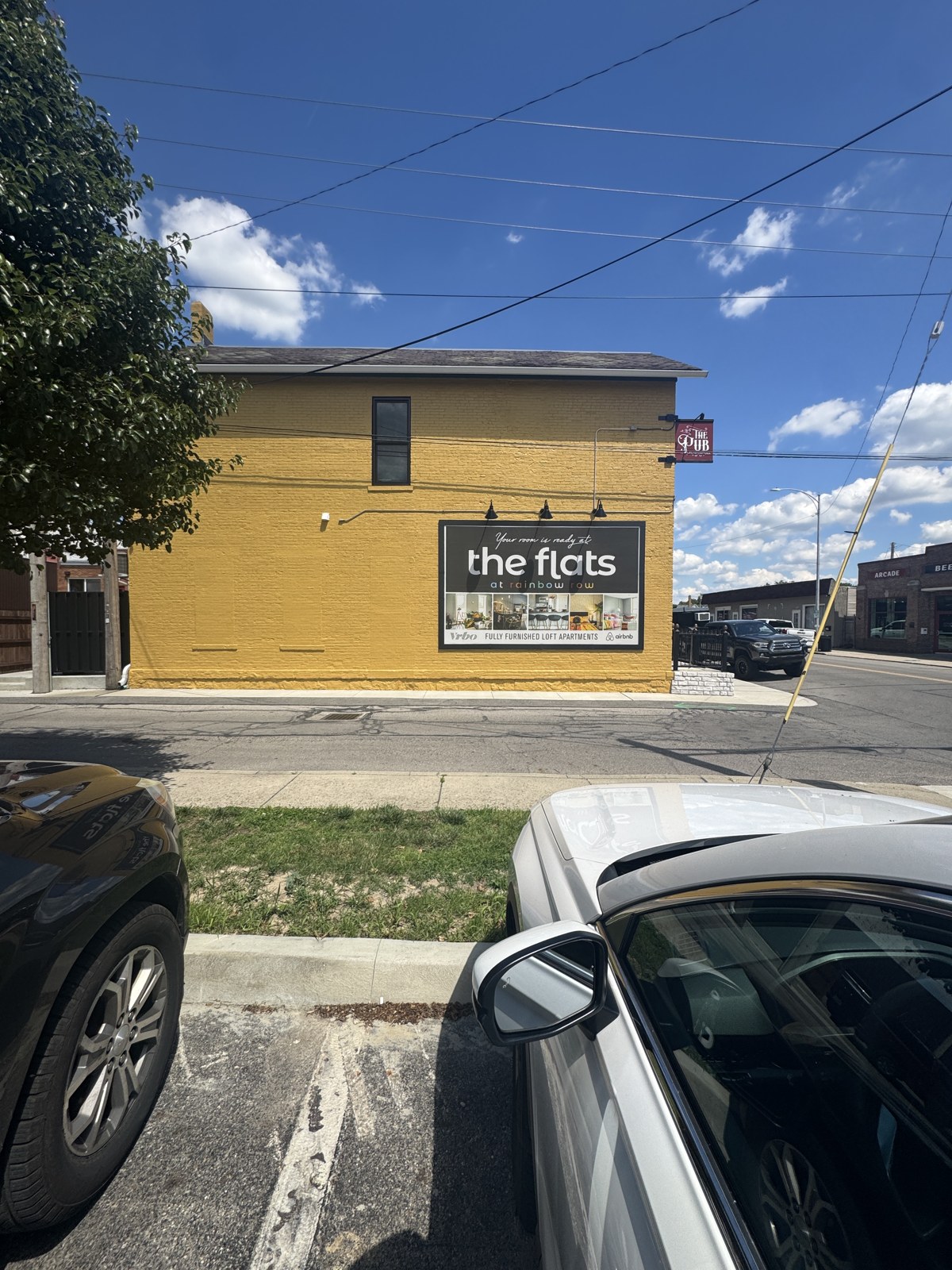 The yellow Flats building with its billboard, seen from the parking lot